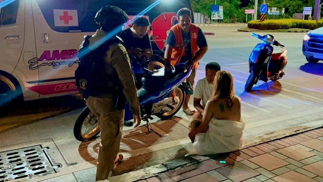 파타야에서 구조대가 상반신 나체 여성을 도우는 모습