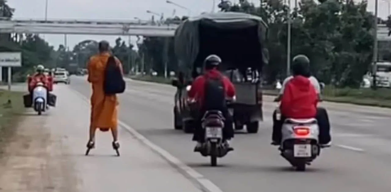 롤러블레이드를 신고 도로를 이동하는 태국 승려