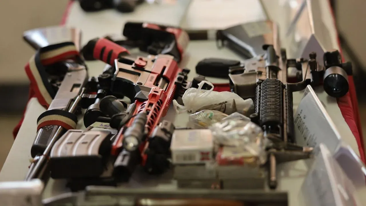 나콘시탐마랏 급습에서 압수된 M16 소총과 수류탄을 전시하는 경찰관